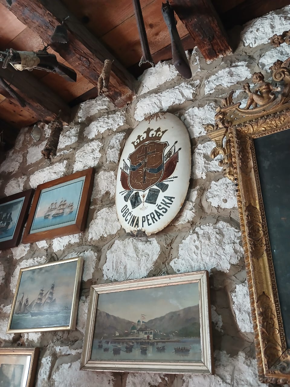 Stari grb Opštine Peraške izložen na kamenom zidu